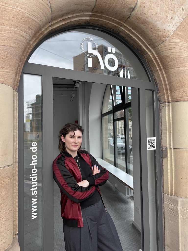 Isabelle Konrad leans in the entrance of studio hö